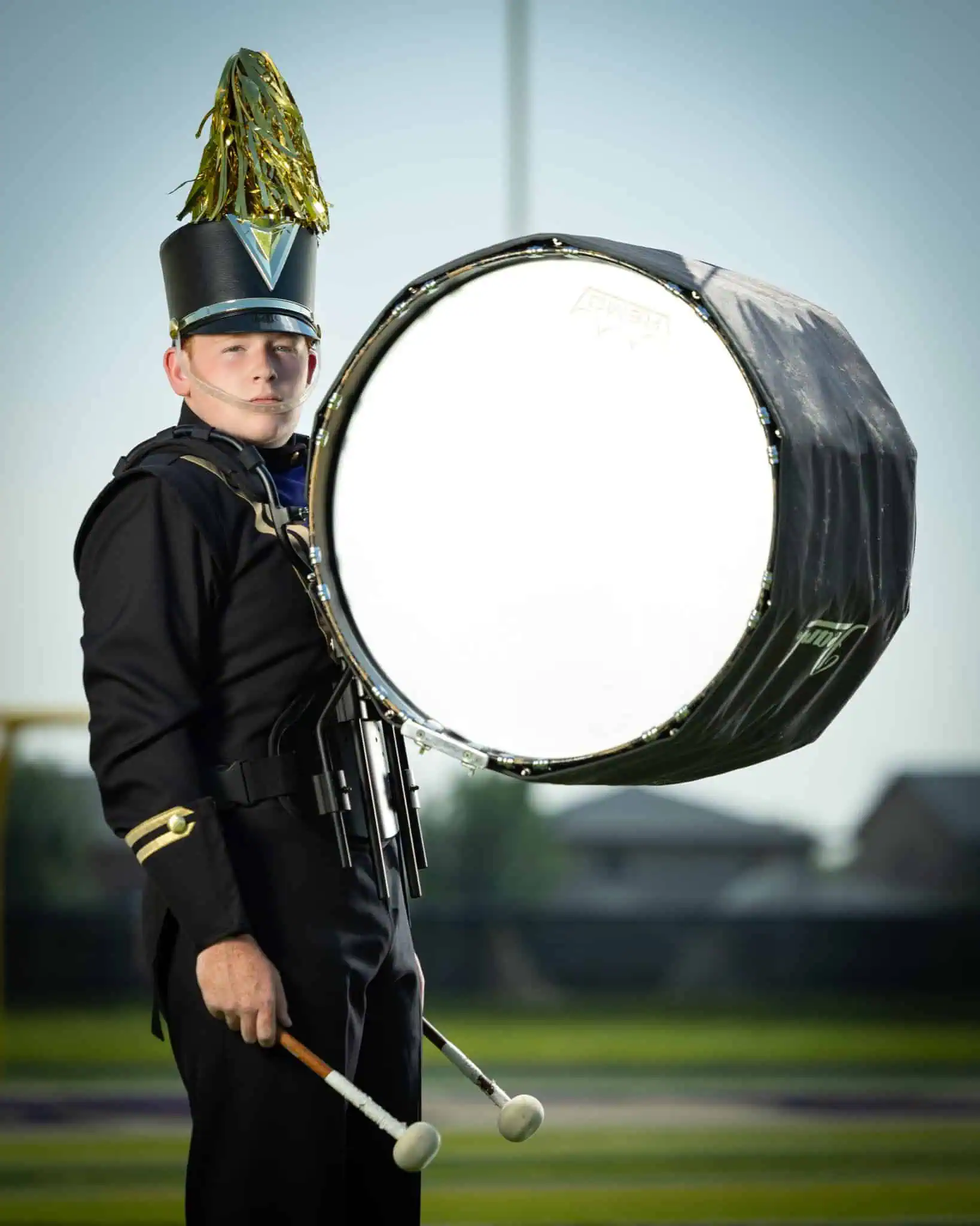 Professional marching band drummer portrait with bass drum showing proper lighting technique