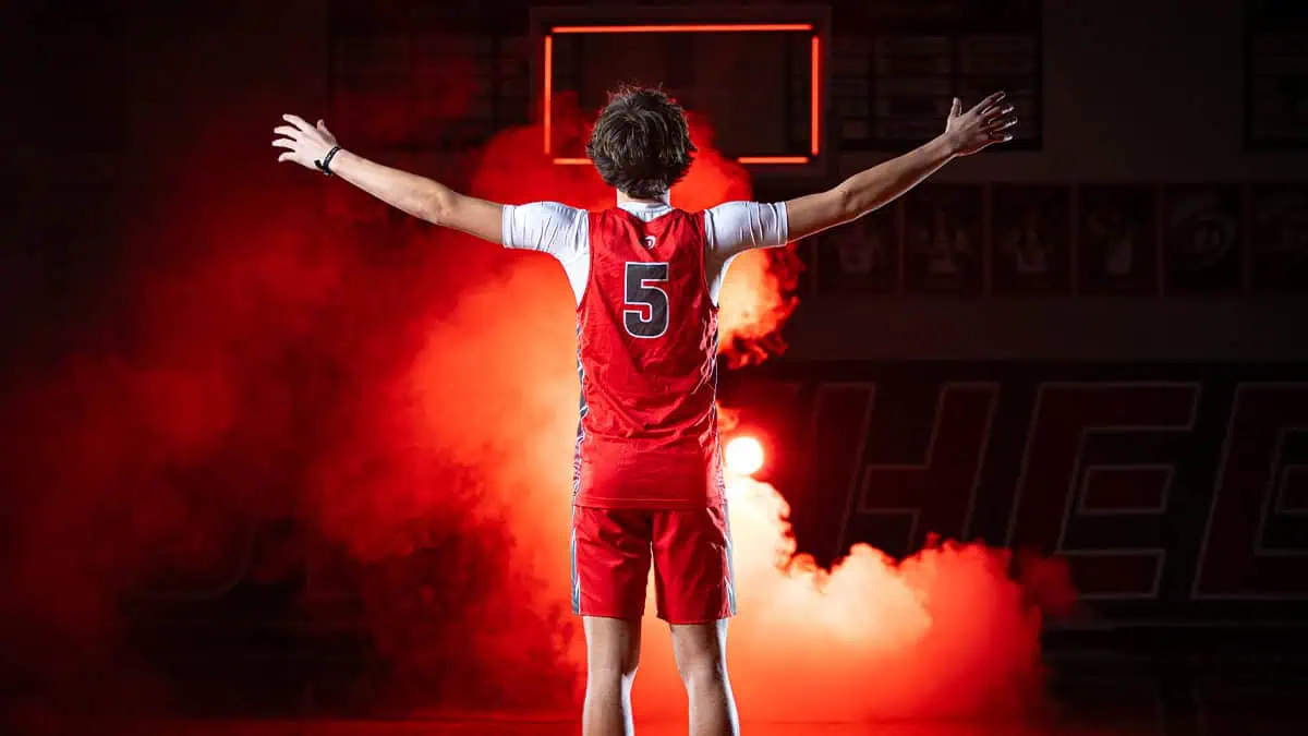 Owyhee High School boys basketball player in red Storm jersey with dramatic lighting